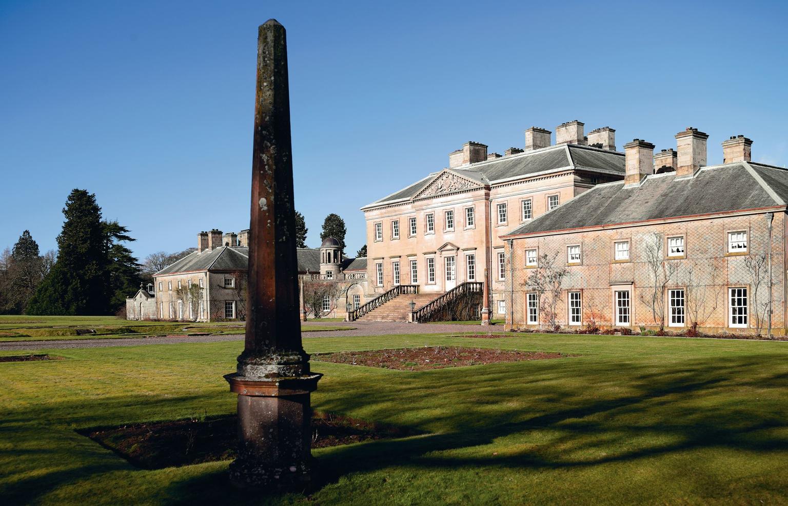 A monolith in front of a stately home