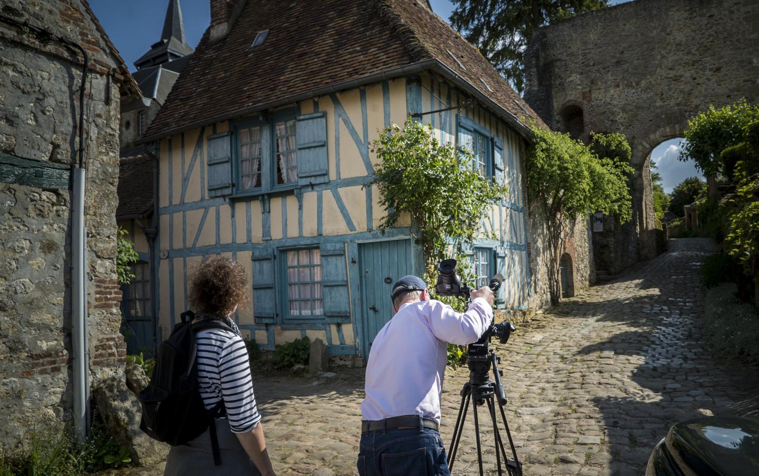 Colour photo of photographer recording video of a street scene in in Gerberoy, France
