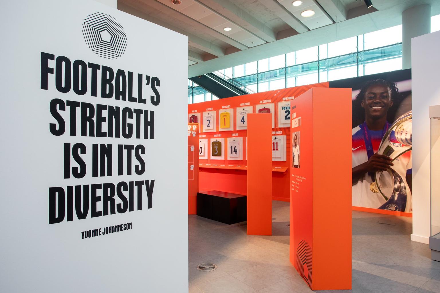 A museum exhibit with a wall text saying 'Football's strength is in its diversity'