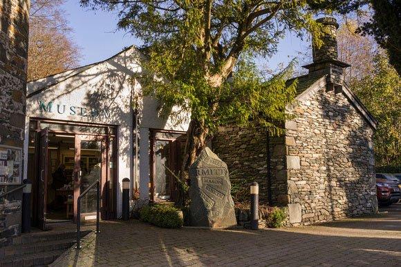 A whitewashed museum entrance with a tree in front