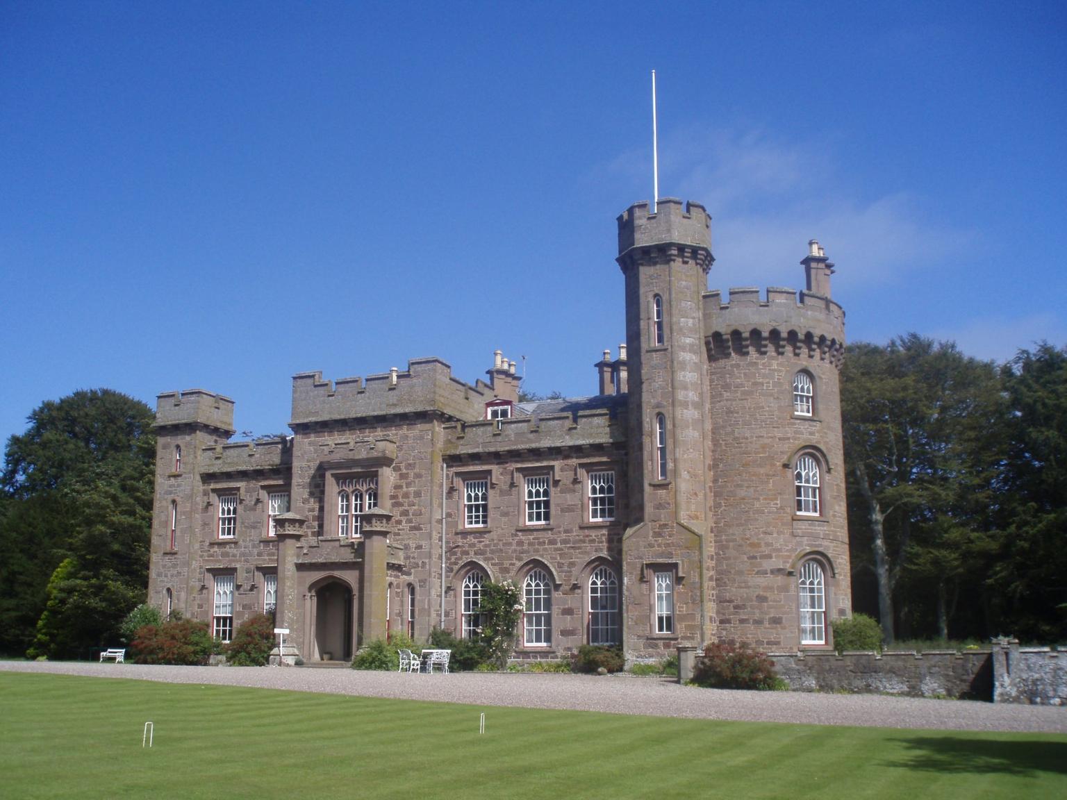 A stretch of lawn in front of a Baronial mansion