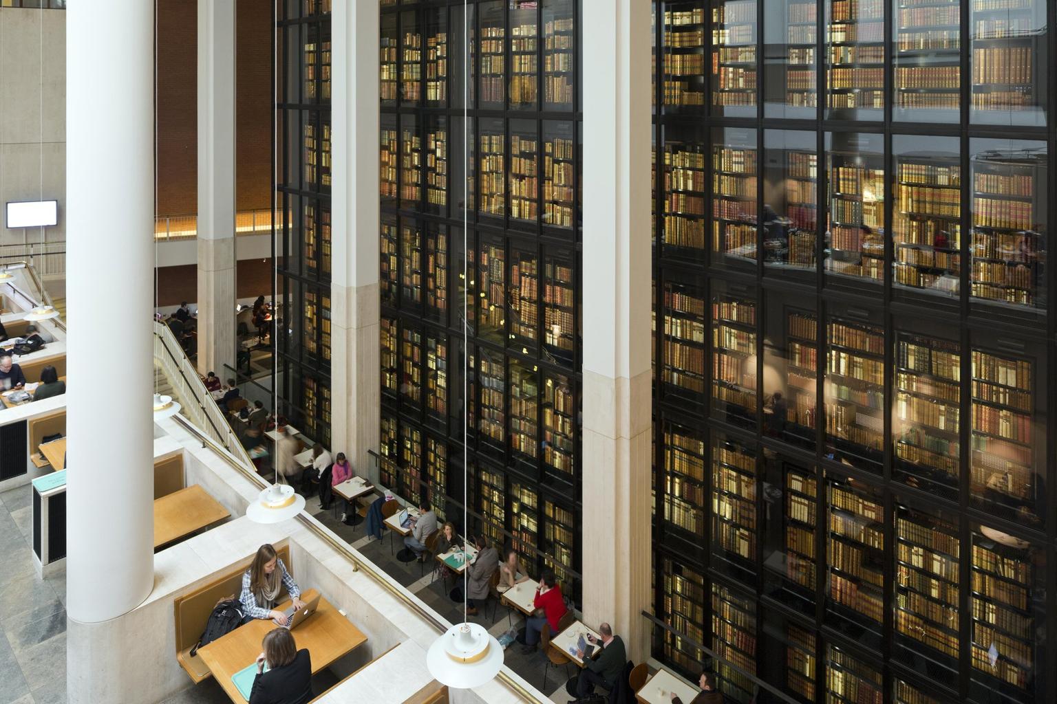A balcony with booth seating overlooking floor to ceiling bookshelves