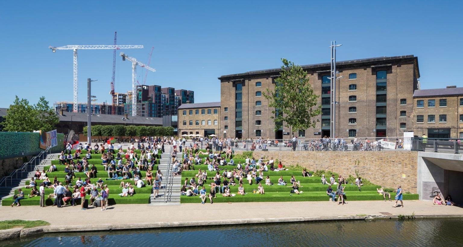 People sitting at lunchtime on the Granarty Square steps at King's Cross