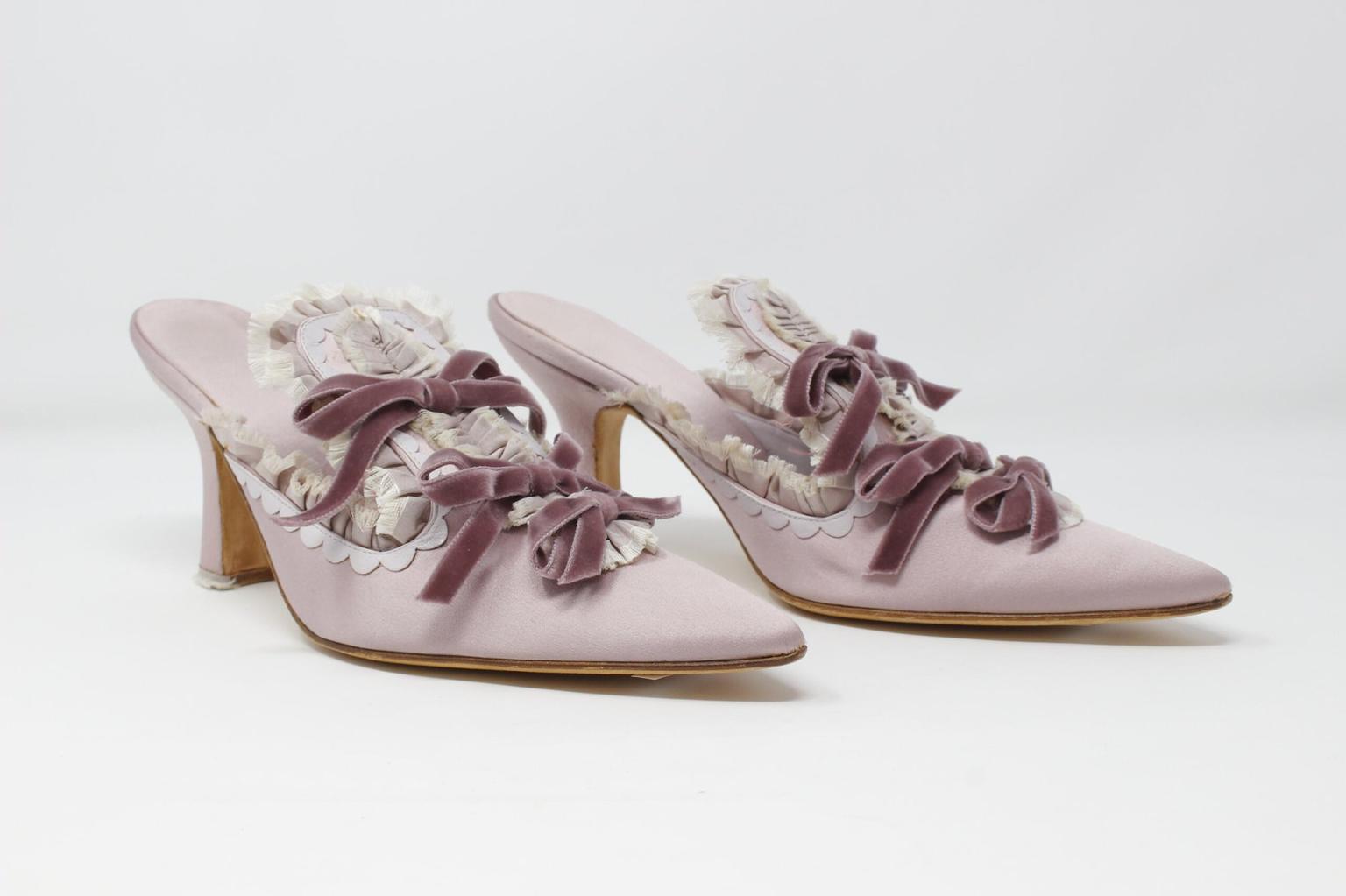 A pair of lilac heels with ruffles and purple velvet bows.