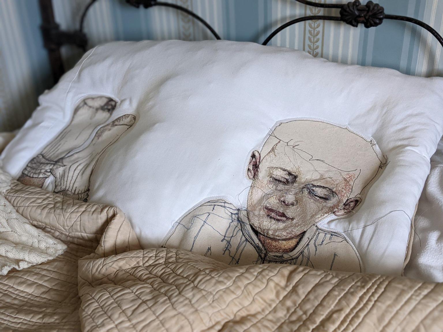 A pillow embroidered with the head and shoulders of a man