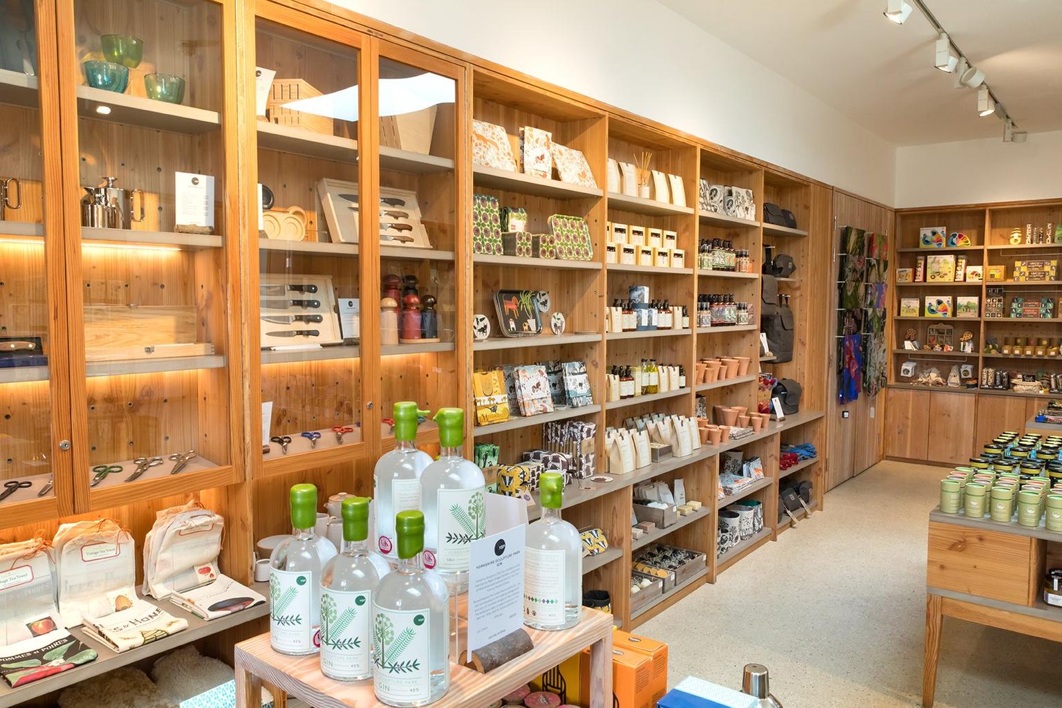 Bright shop interior with wooden shelves filled with neatly arranged homeware items and gifts.