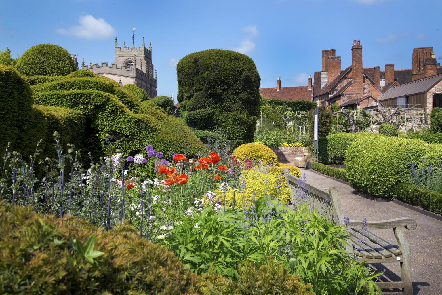 Gardens in bloom with historic houses in the background