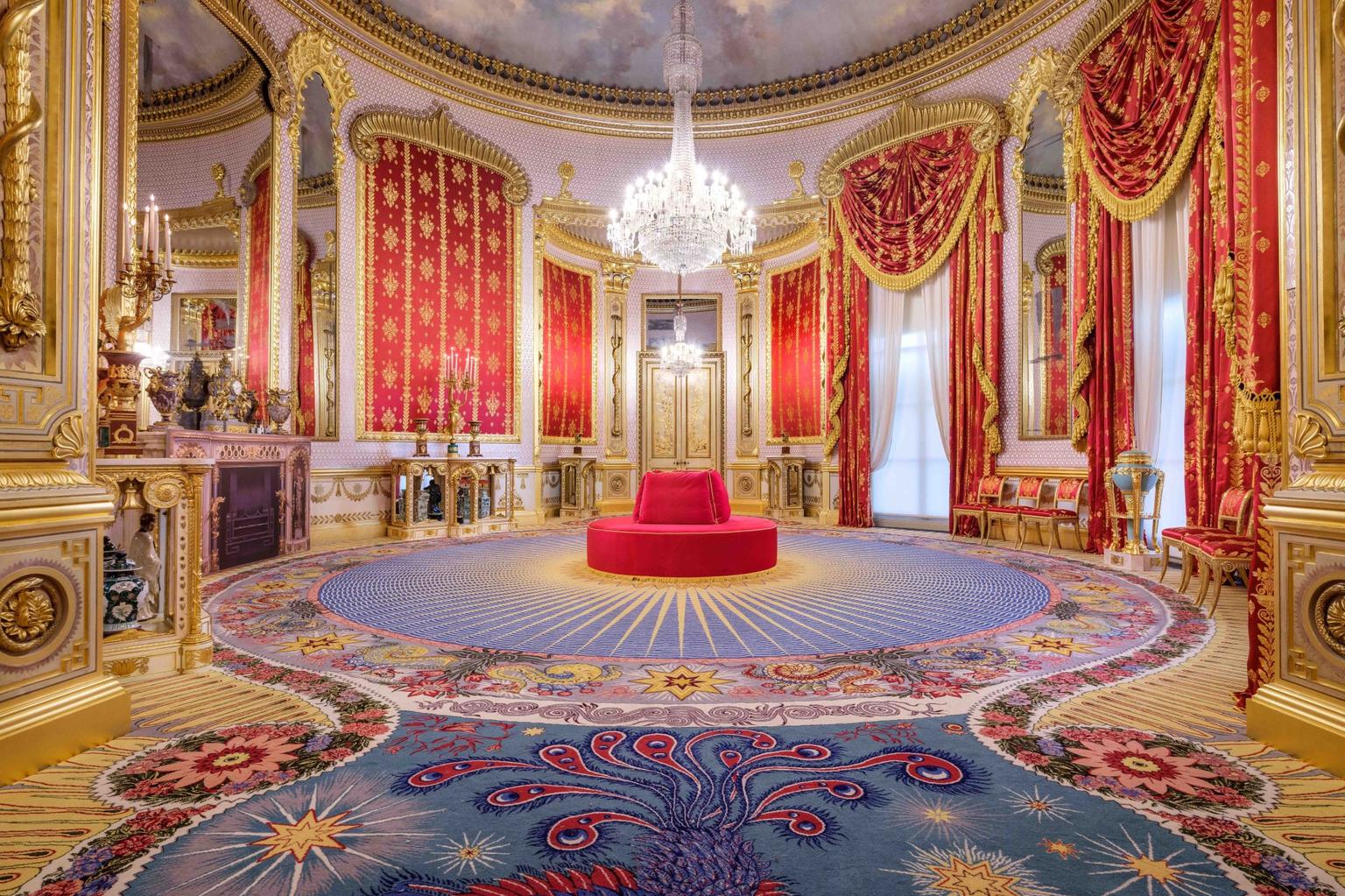 A highly decorated circular room with ornate curtains, carpet and a chandelier