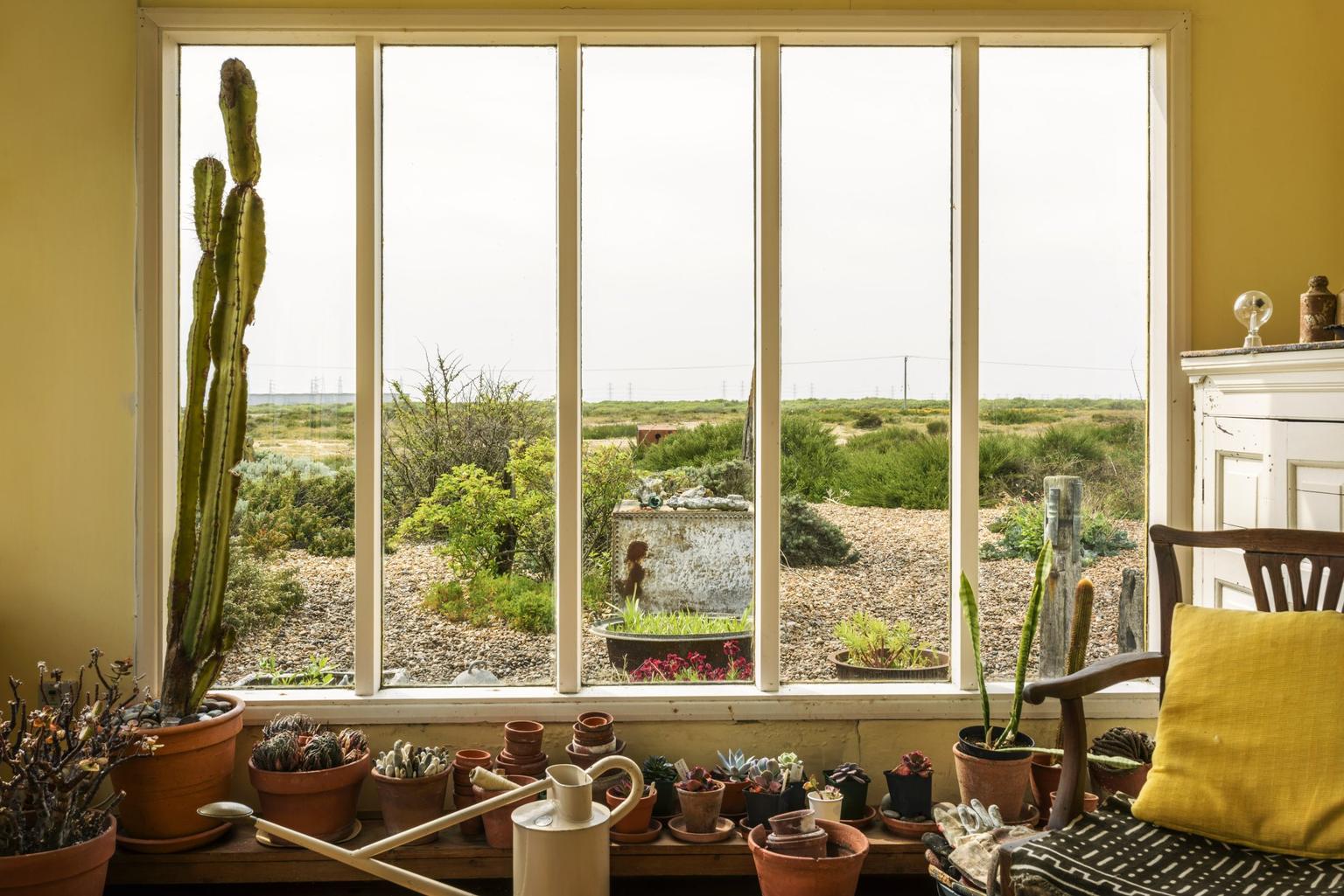 The view from the window of a cottage with a pebble shingle beyond