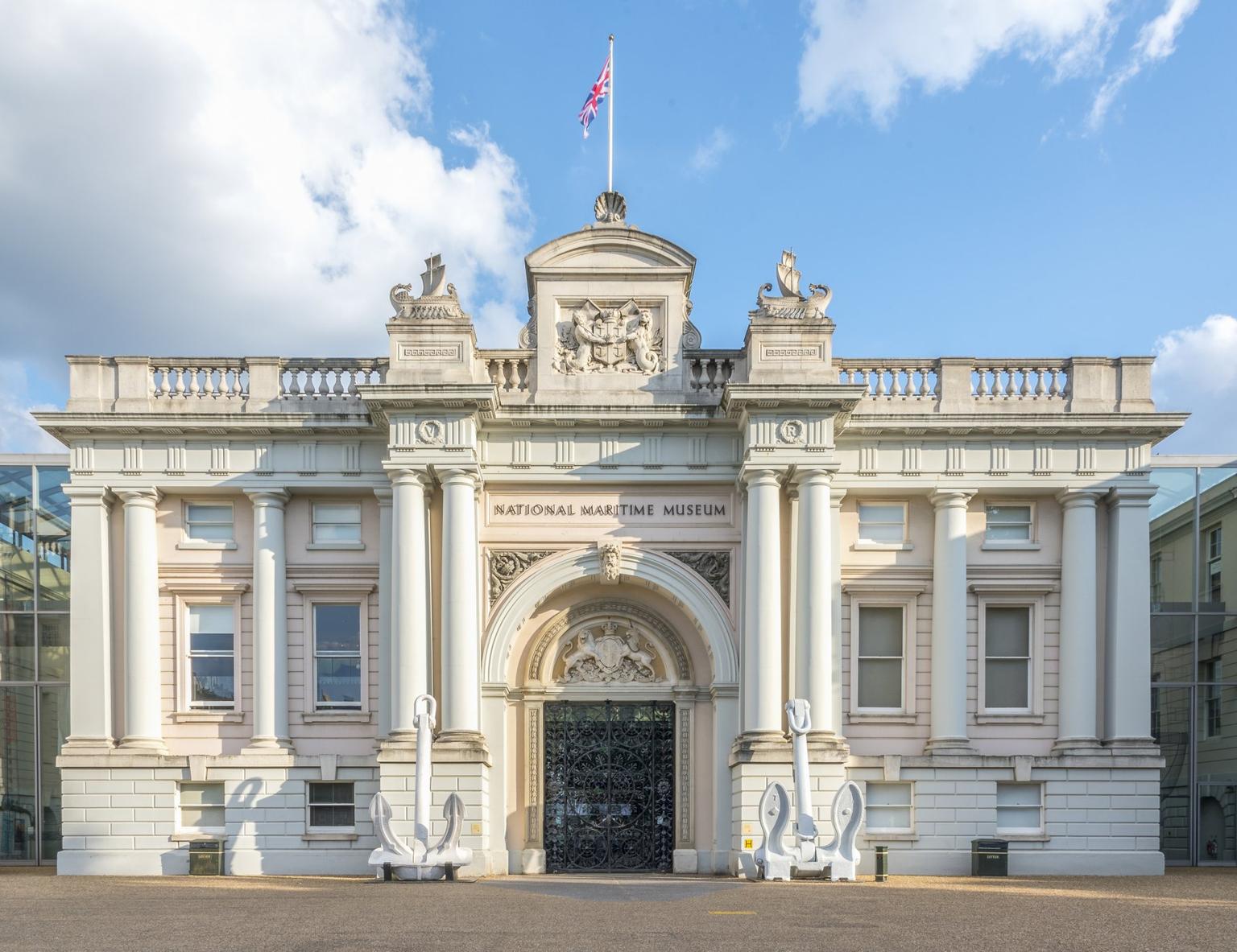 The exterior of the National Maritime Museum, a neoclassical building with a pink facade and cream columns.