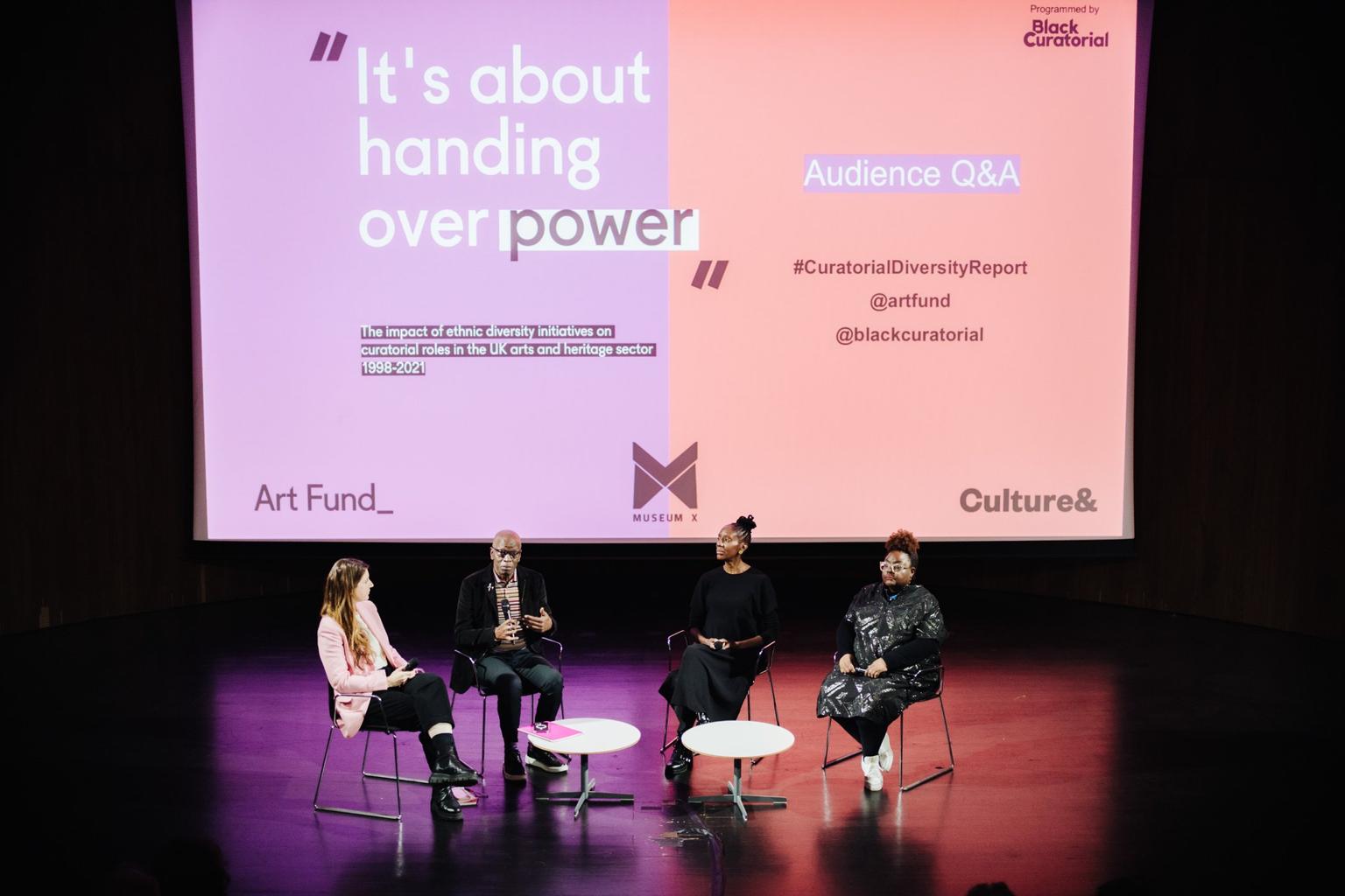 Four presenters on a conference stage