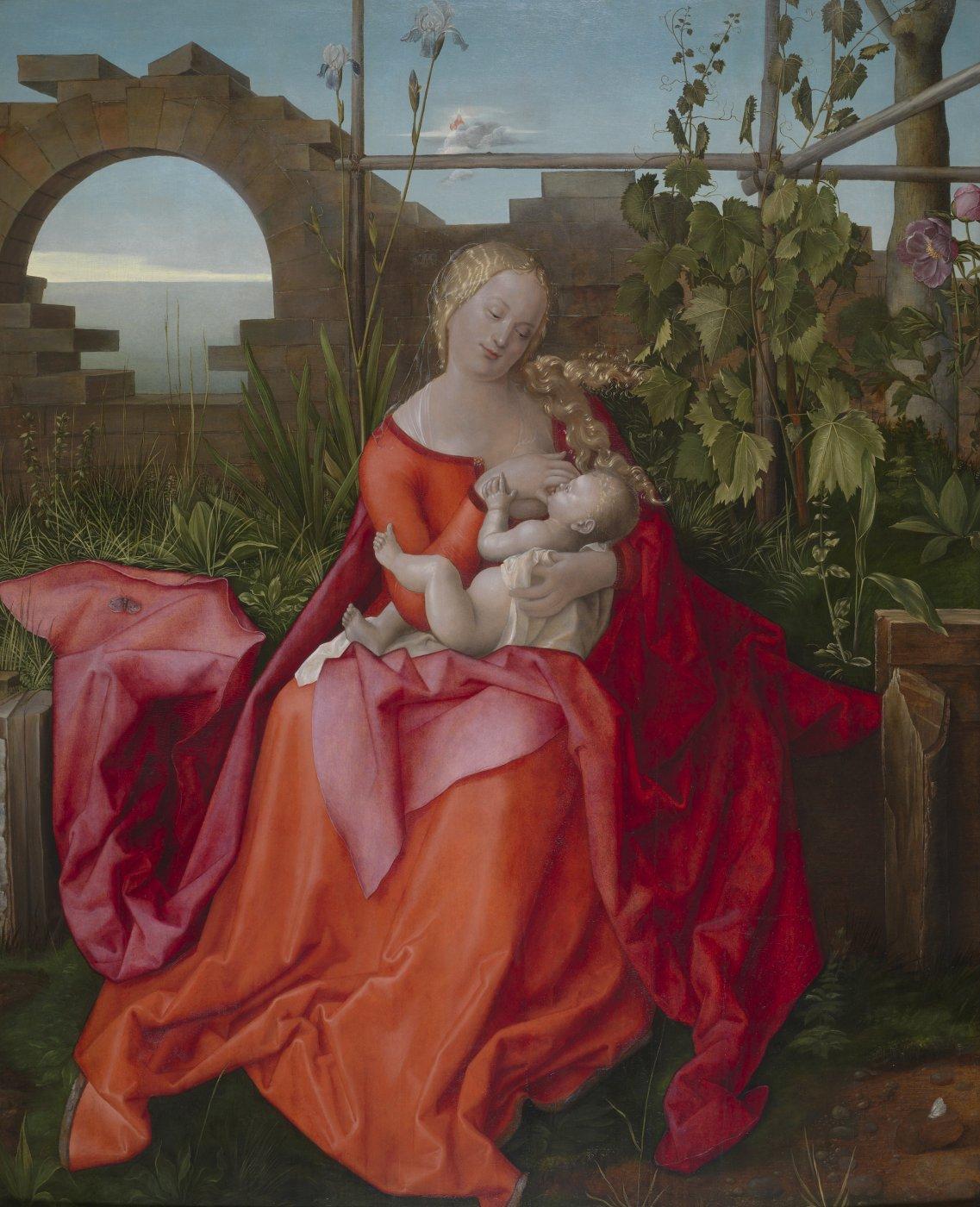 The Virgin May fits in a garden, nursing the baby Jesus. She is wearing a luxurious orange road and is draped with a red shawl. Her hair is golden.