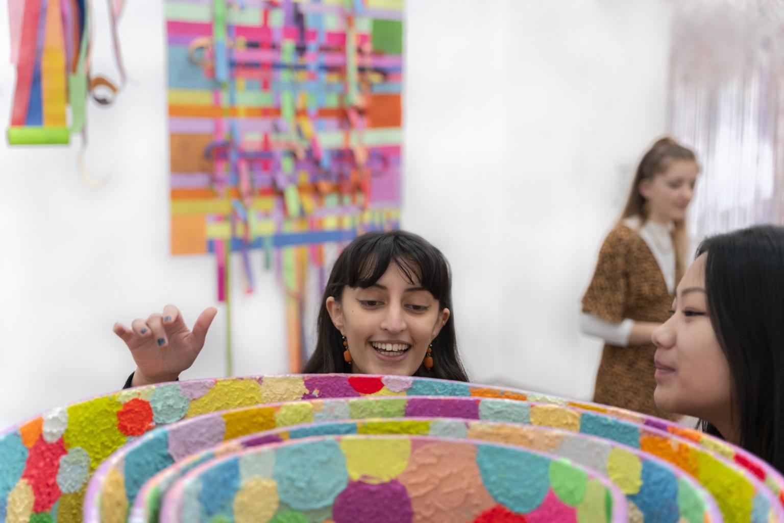 Visitors look at a colourful sculpture