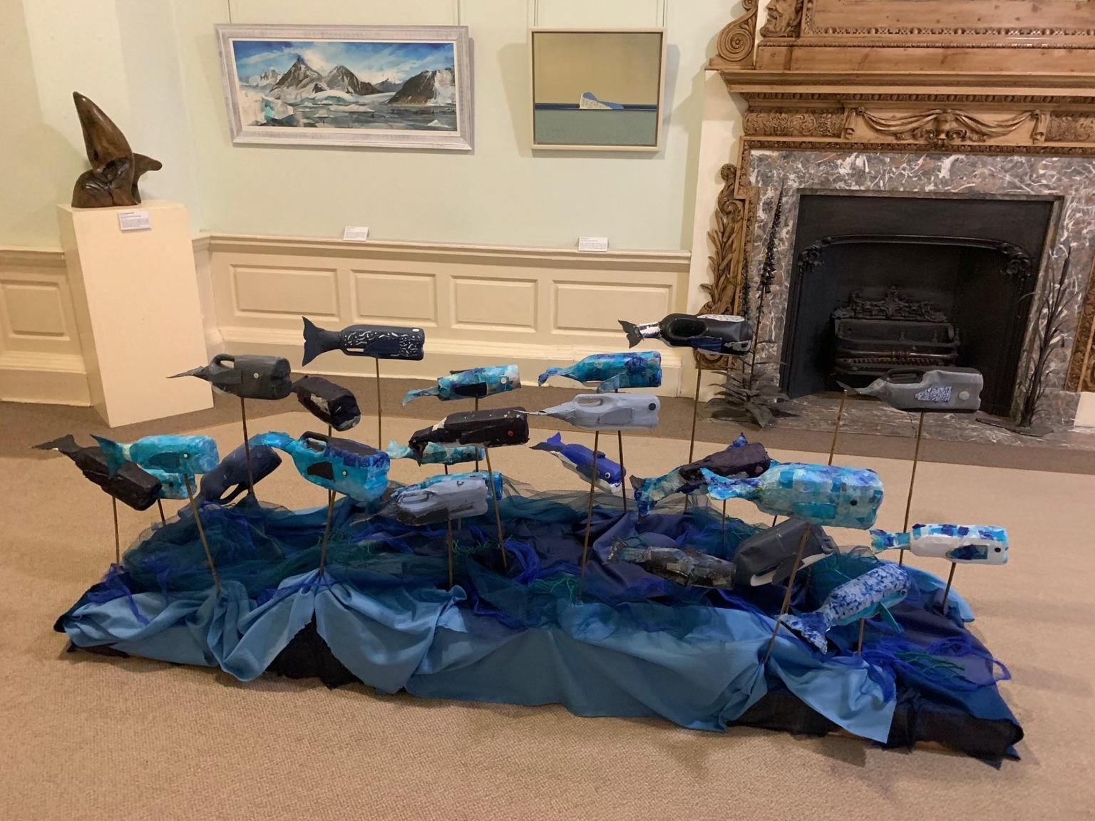A floor based sculpture of whales