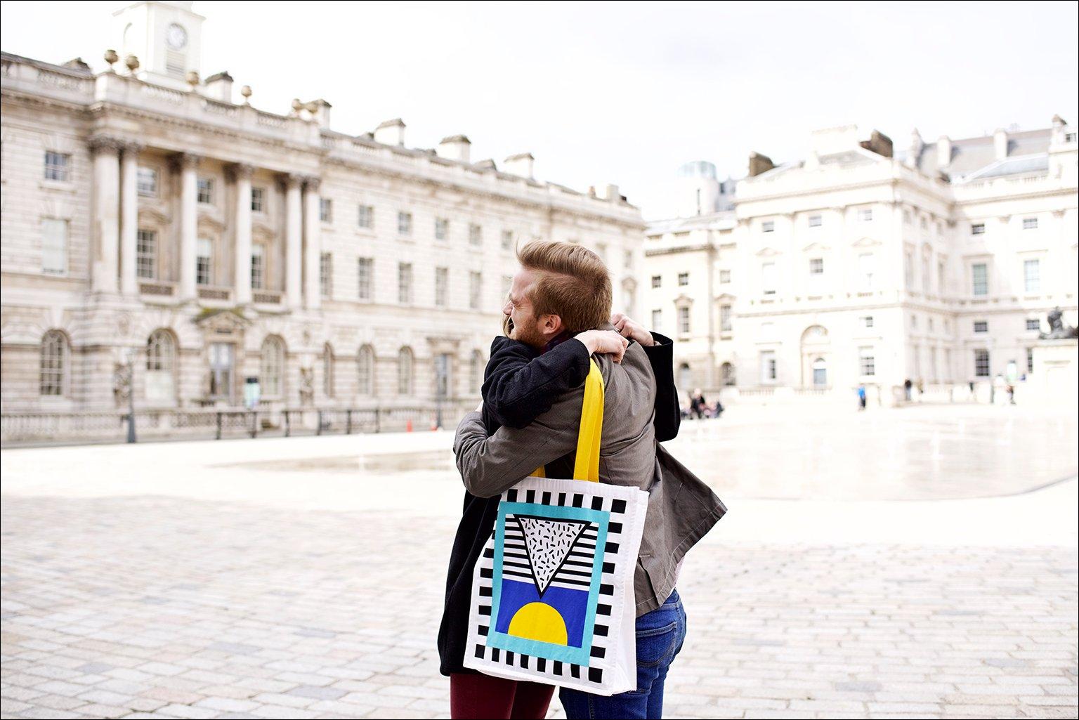 Two friends share a hug in the courtyard of Somerset House
