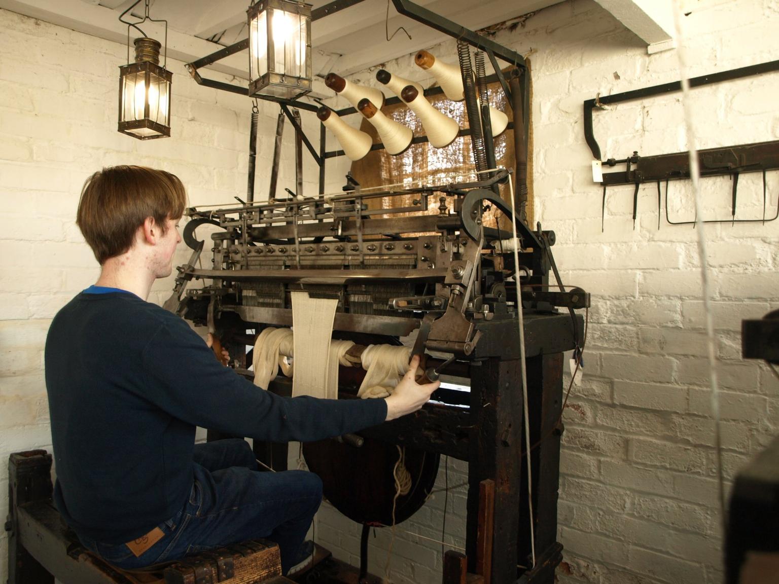 A man sits to demonstrate a hand frame