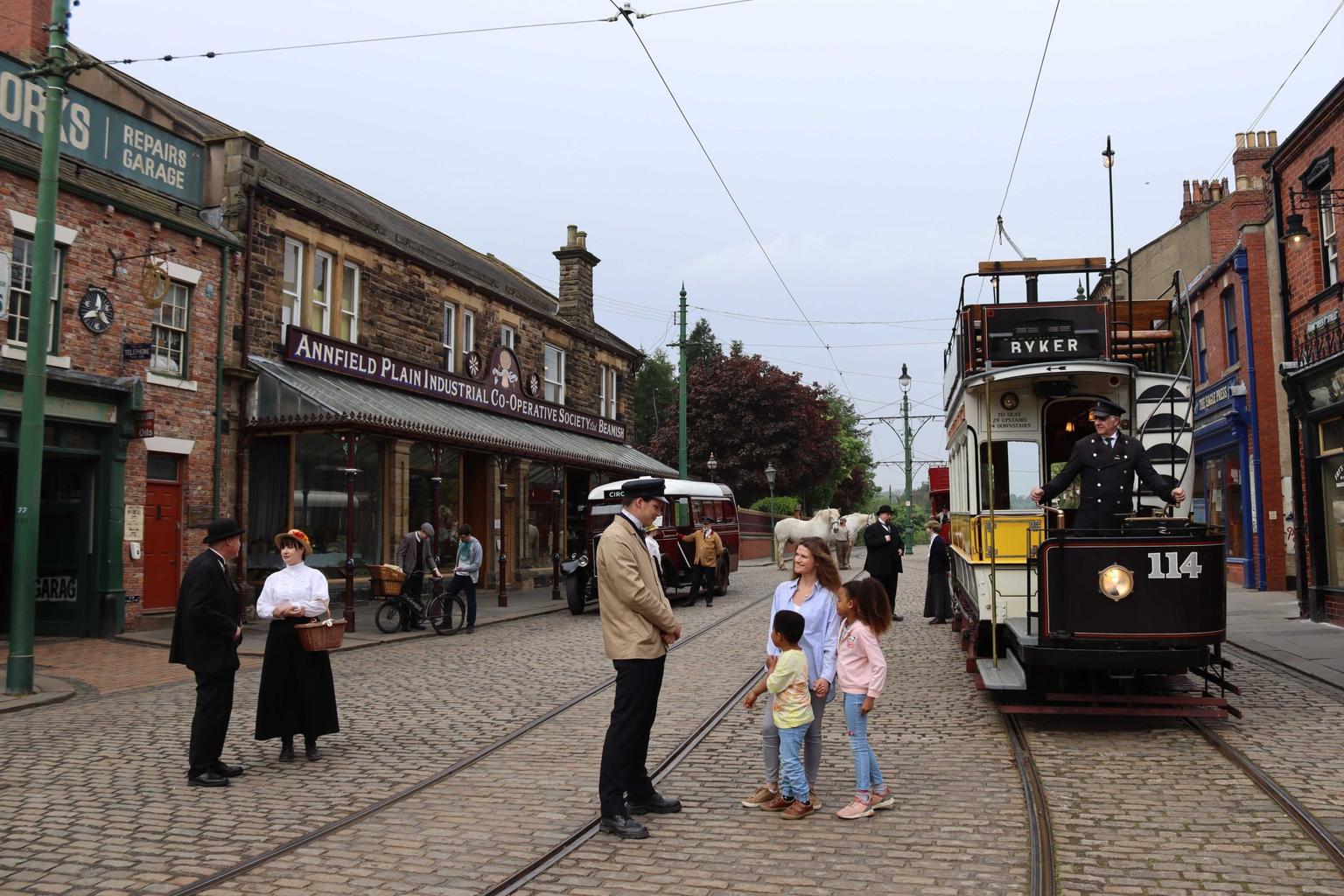 A recreation of a historic street with old tramway and people in historic costume