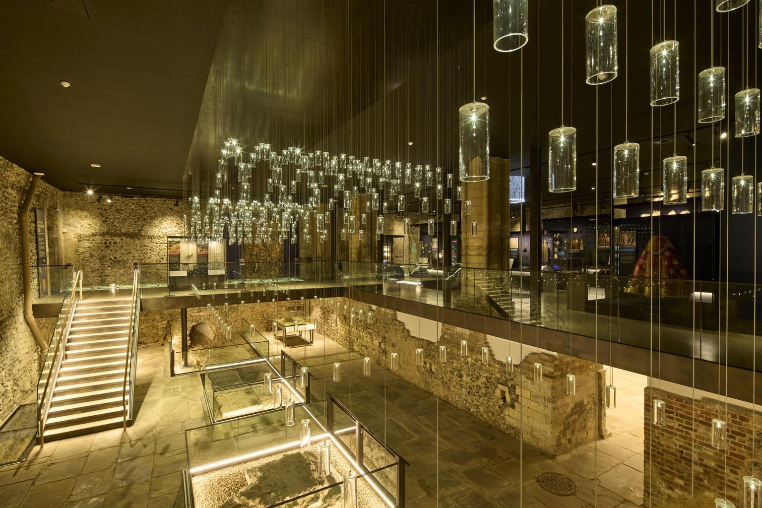 A double height stone space hung with glass lights