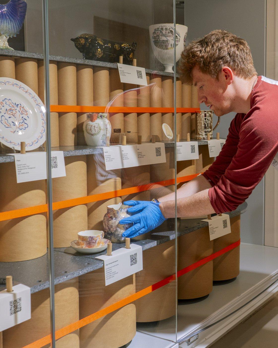 Assistant curator Michael Ruddy rotating the Unpacking the V&A Wedgwood Collection display.