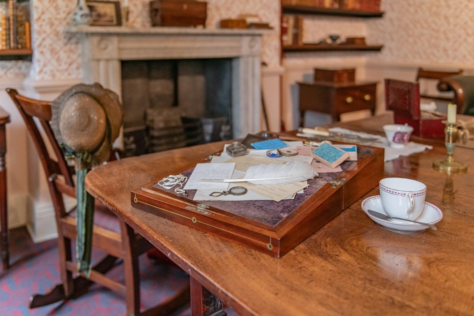 A table laid with Victorian writing materials, in a historic room.