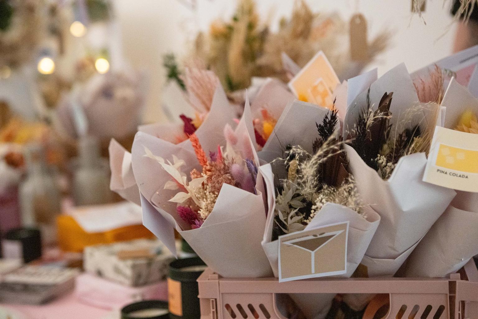 Paper-wrapped bunches of dried flowers with fairy lights in the background