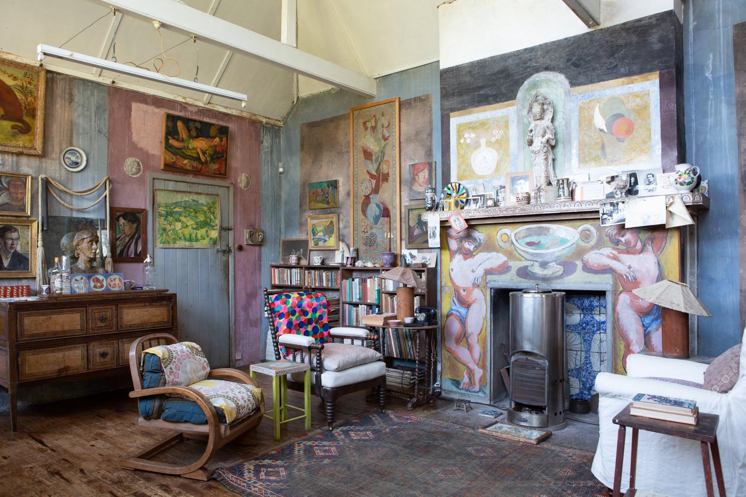 A colourful room with painted walls and fireplace, artwork and furniture