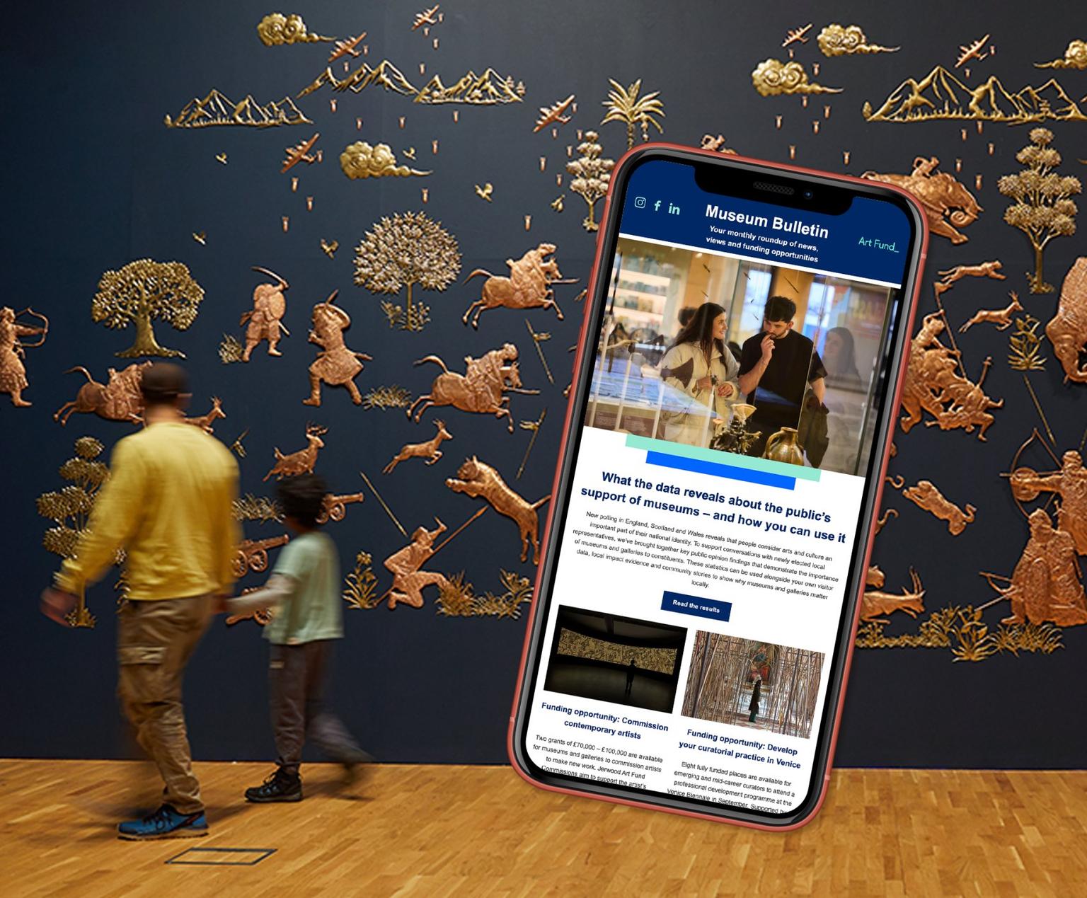 Smartphone displaying the Museum Bulletin newsletter floats over visitors walking past a dark blue wall adorned with gold relief animals and figures