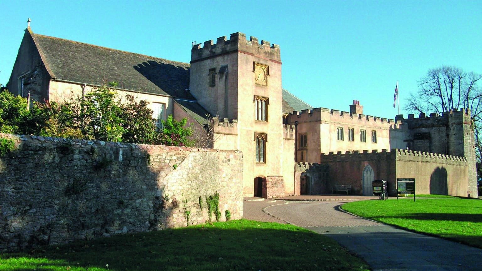 The exterior of a historic abbey, with crenelated walls