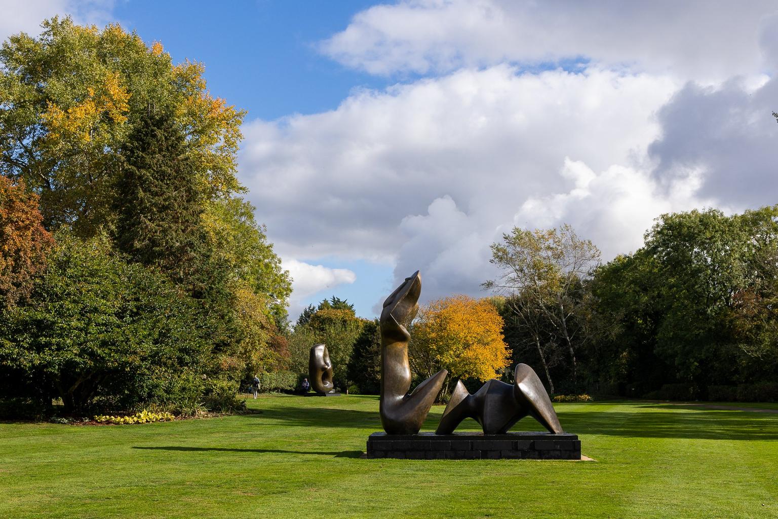 Bronze sculpture on a lawn surrounded by autumnal trees