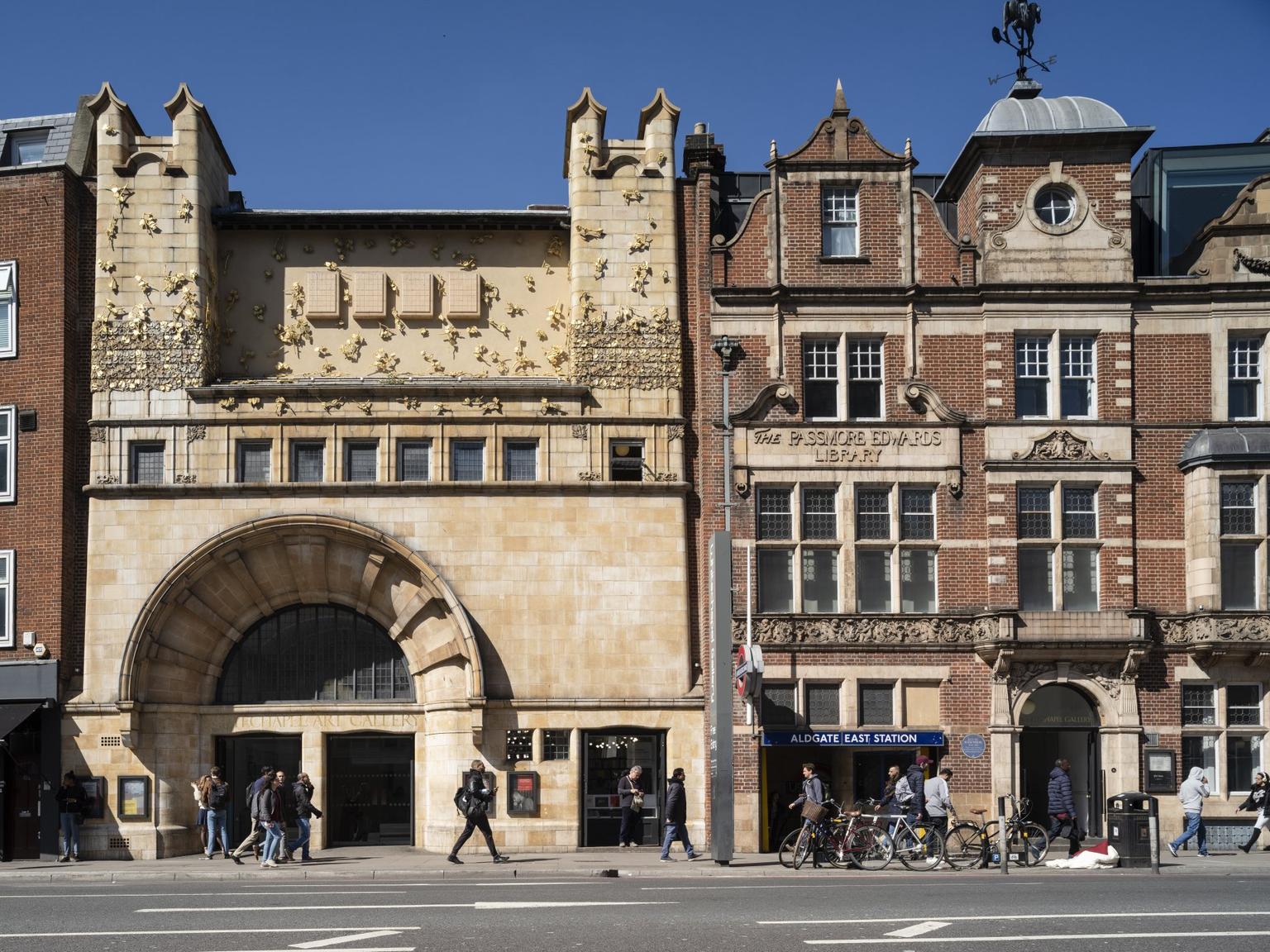 The exterior of the Whitechapel Gallery; the building has a distinctive terracotta tiled facade with the large arched windows on the street level entrance.