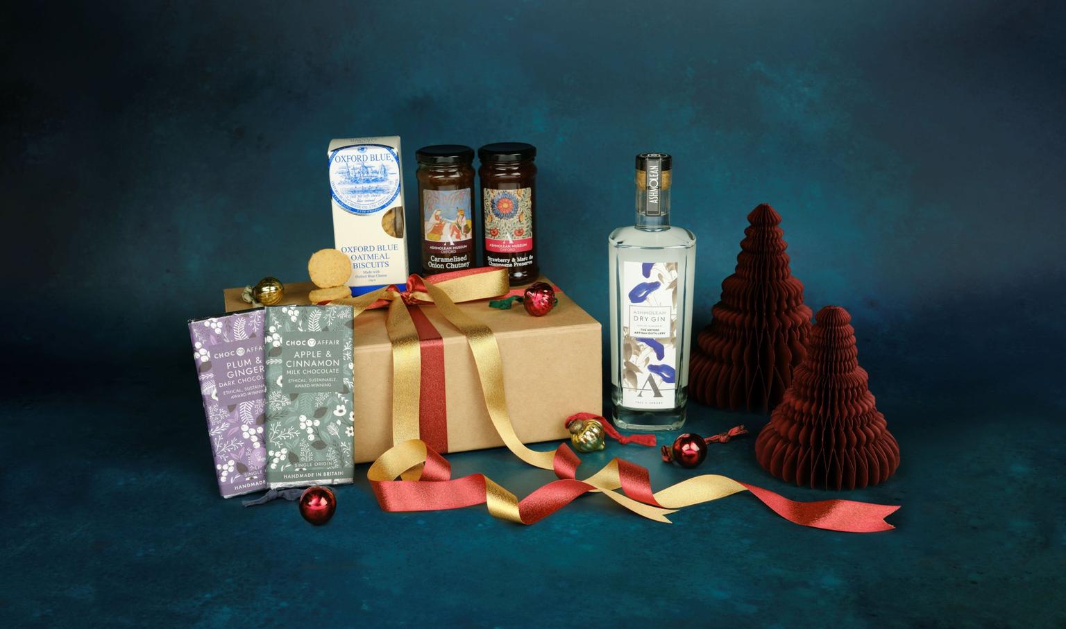 A selection of Christmas gifts on a blue background including chocolate and chutneys