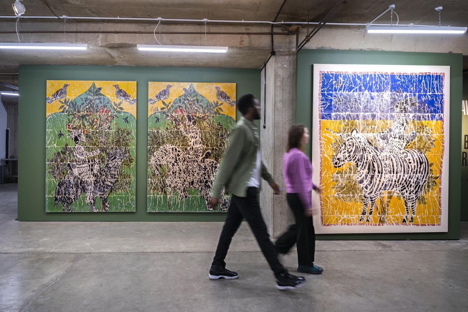 Visitors walking in front of two artworks