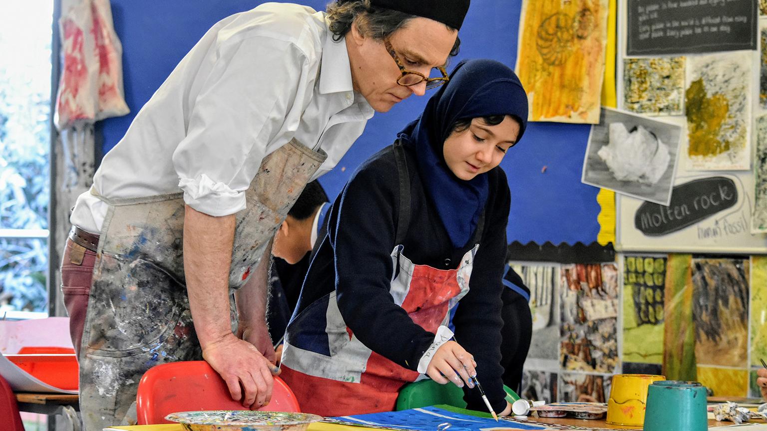 Artist Alexander Newley assisting a pupil at Preston Park Primary, Wembley, London, 2019