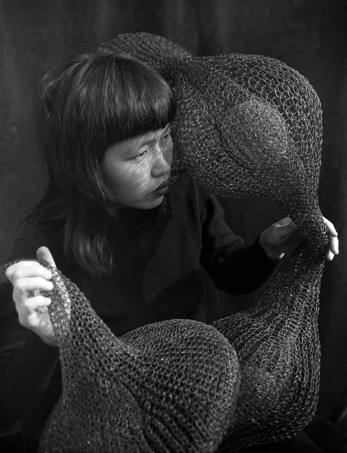 Ruth Asawa holding a form-within-a-form sculpture, 1951.